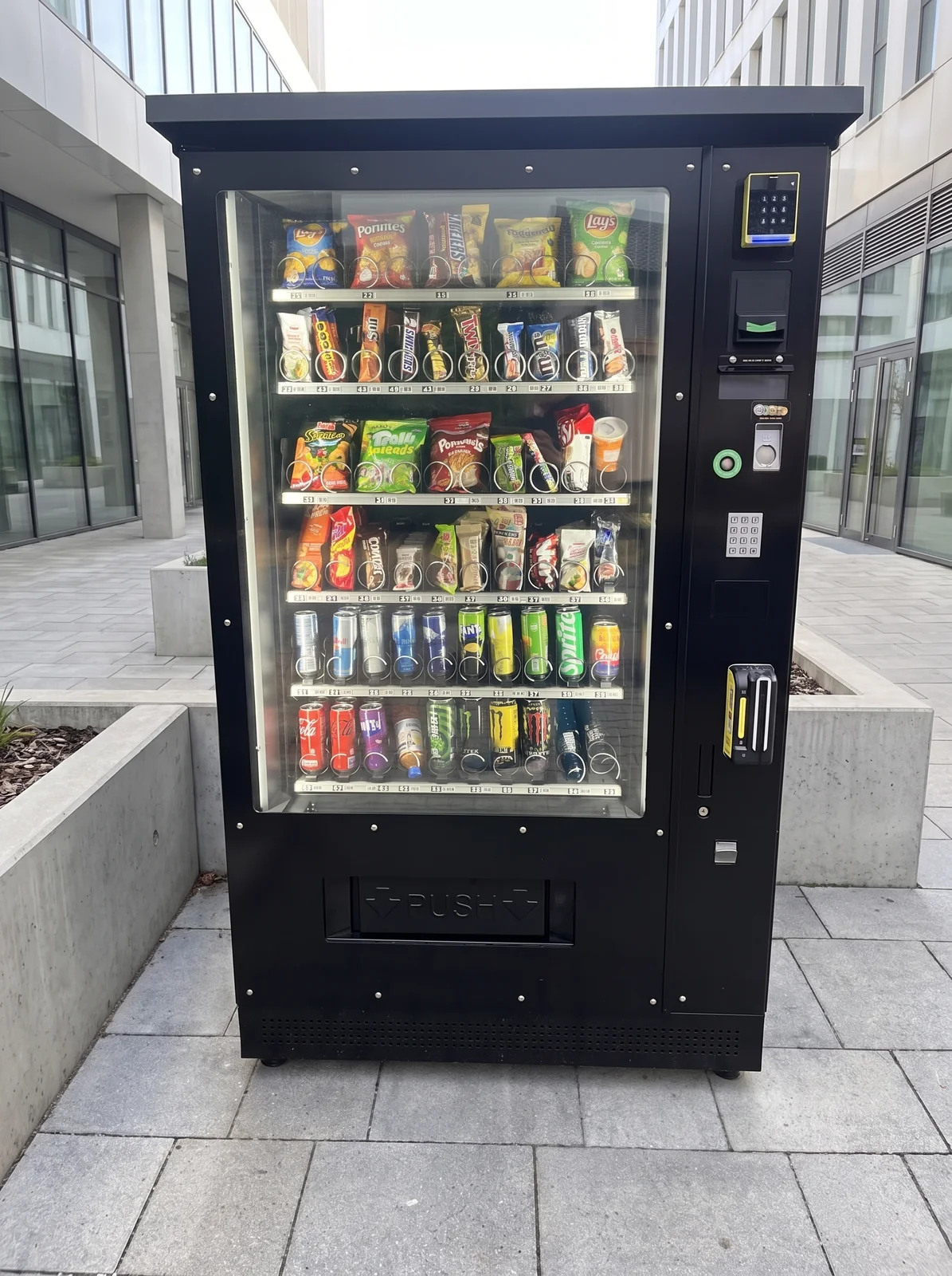Schwarzer Snack- und Getränkeautomat von Automaten Service Zimmermann in einem hellen, modernen Eingangsbereich